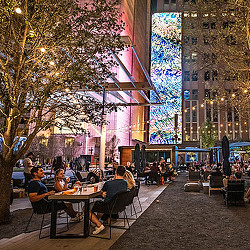 People sitting at tables outside.