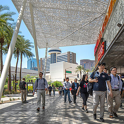 A group of people walking on a sidewalk.